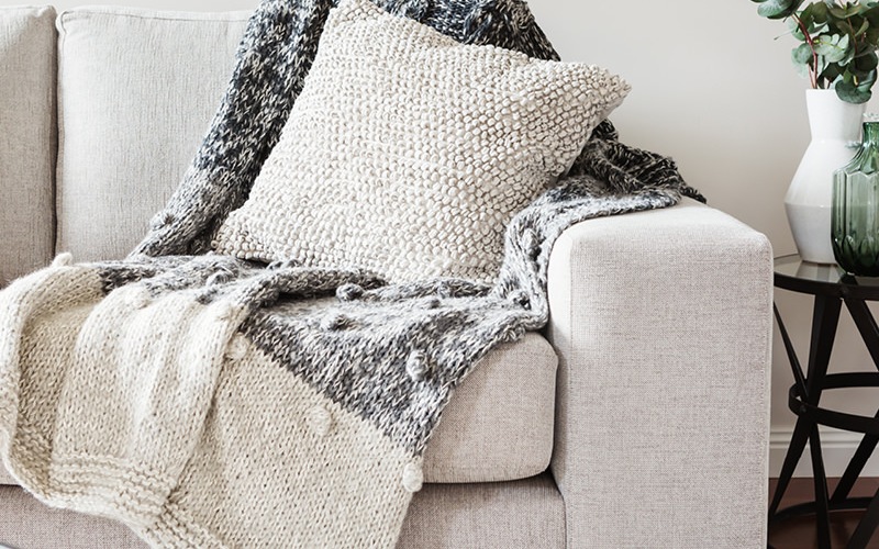 Stock image of a cozy sofa and blanket